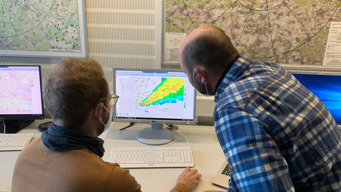 Zwei Mitarbeiter schauen im radiologischen Lagezentrum auf einen Computerbildschirm. Dort sind die Radioaktivitäts-Messwerte und die Ausbreitung der Radioaktivität auf dem Landesgebiet nach einer simulierten Freisetzung radioaktiver Stoffe zu sehen.