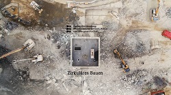  Titelbild des Films "Zirkuläres Bauen" vom Umweltministerium. Es ist eine Luftbildaufnahme von einer Abriss-Baustelle. Es sind mehrere Bagger in verschiedenen Bereichen am Arbeiten. es gibt unterschiedliche Haufwerke wie z.B. Betonbruch, Baustahl.