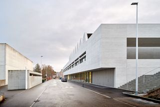 Am leicht abfallenden Hang liegt entlang der Schulstraße der langgestreckte Neubau Z, der als zweigeschossiges Volumen einen verbindenden Außenraum zum Gebäude M auf der gegenüberliegenden Straßenseite schafft.