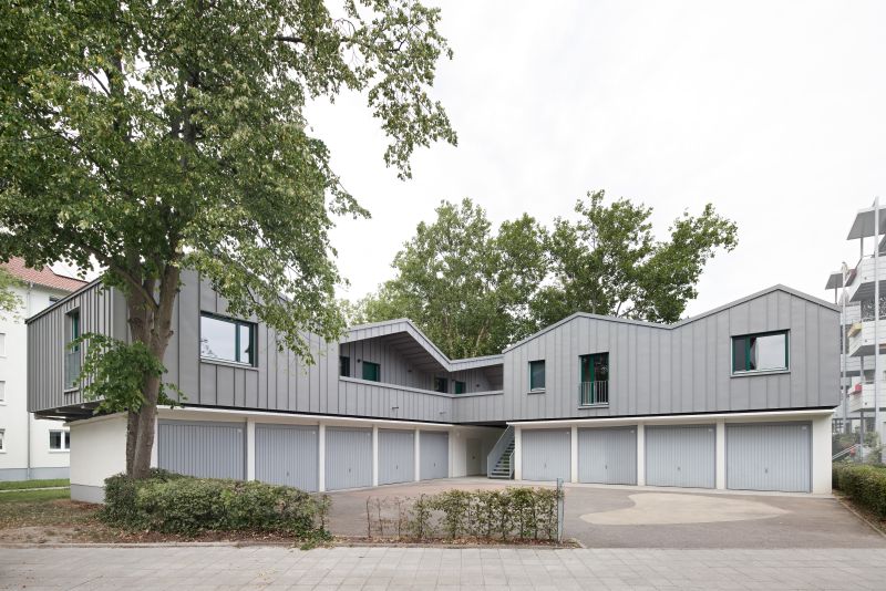  Blick auf die beiden rechtwinklig zueinander angeordneten Garagenseiten (jeweils vier Garagen), mit den aufgesetzten Wohneinheiten.