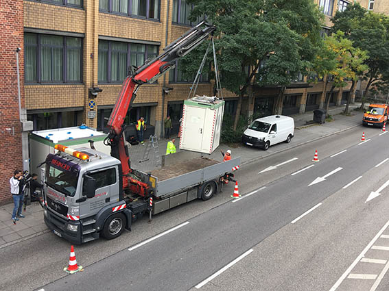 Medienvertreter macht Filmaufnahmen vom Absetzen des neuen Containers.