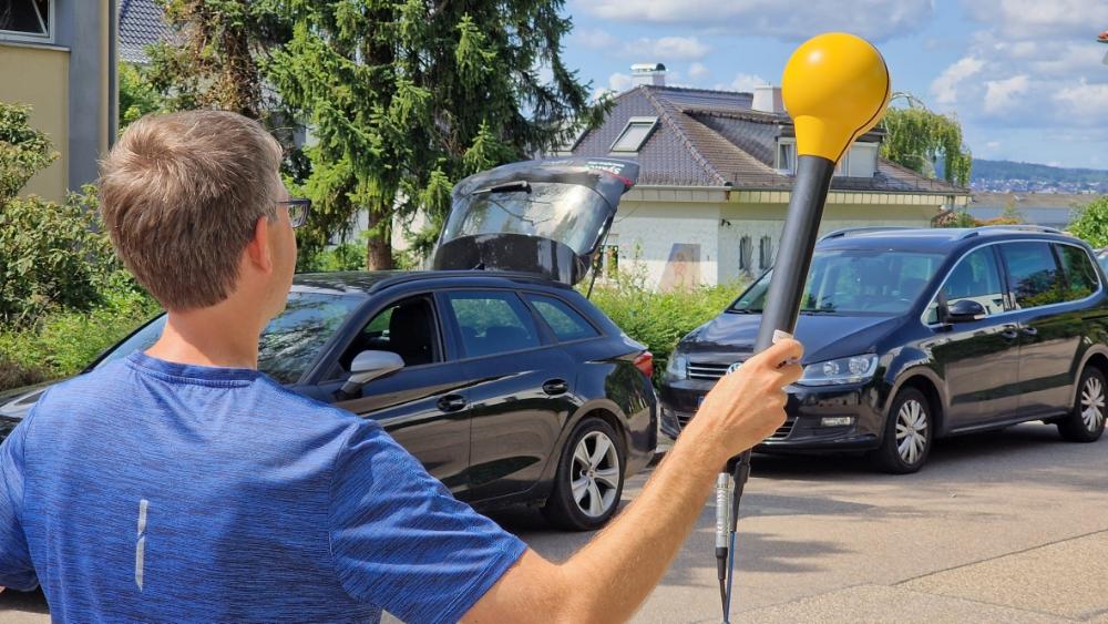 Messingenieur hält Antenne vor Wohnhaus
