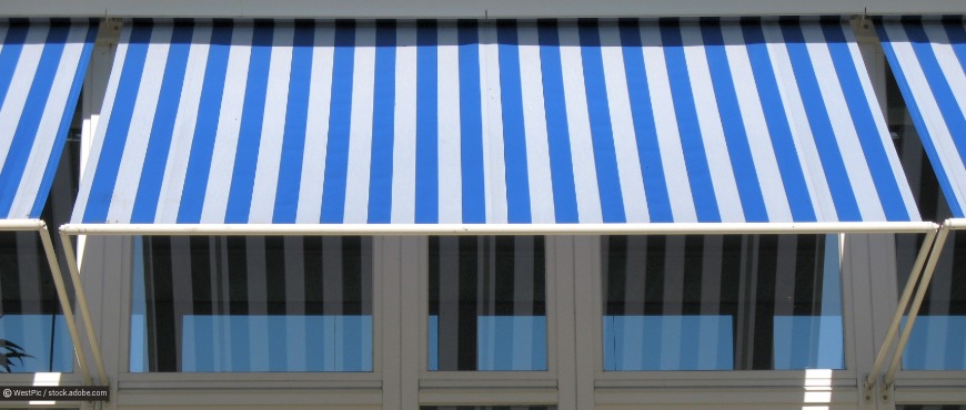 Blauweiße Markiese schützen das Fenster vor der Hitze