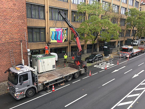 Der neue bunte Container wird vom Lastwagen gehoben. 