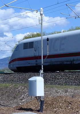 Bahnlärmmessstation in Achern, im Hintergrund ein ICE